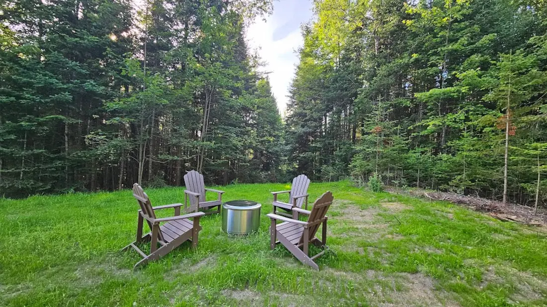 Adirondack chairs around the fire pit on the lawn