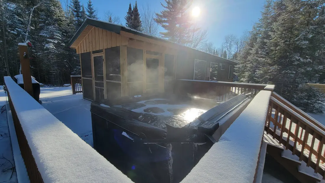 The hot tub on The Modern Pine's deck in the snow