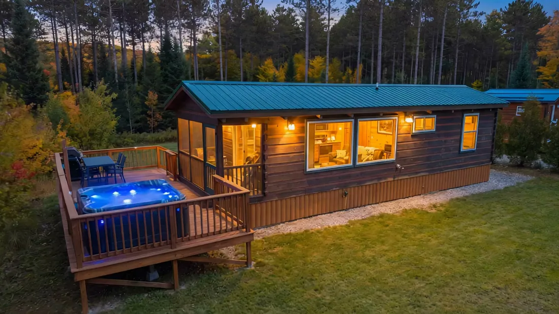 The Modern Tiny Home at dusk, its hot tub lit on the deck